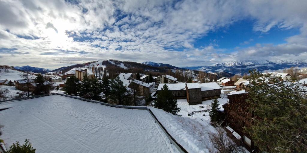 une ville enneigée avec des montagnes en arrière-plan dans l'établissement Studio vue panoramique, à Péone