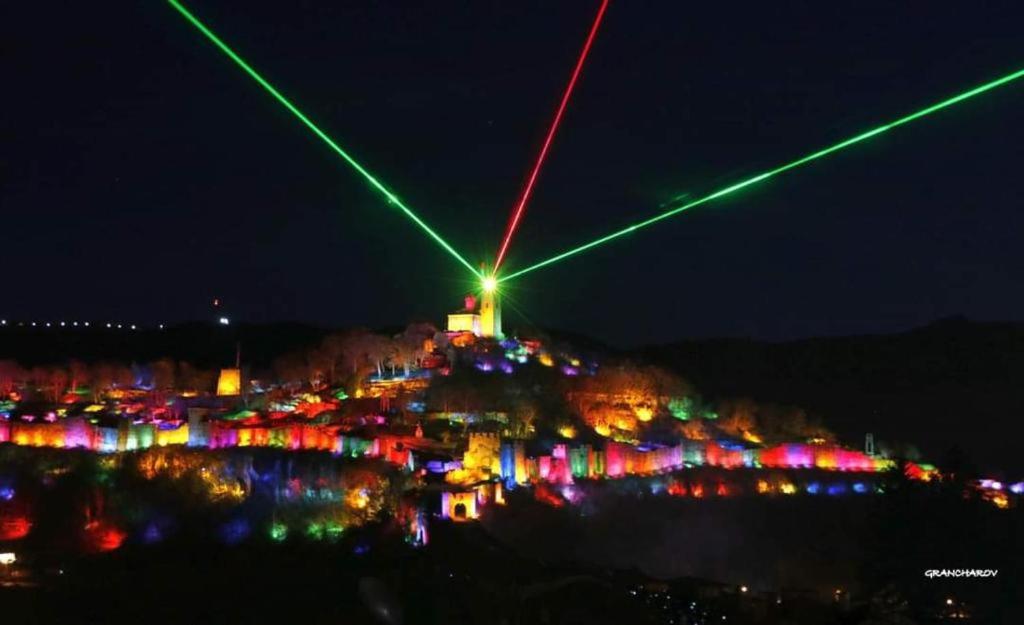 a city lit up at night with lights at СТОНЕЛ-семейно студио in Veliko Tŭrnovo