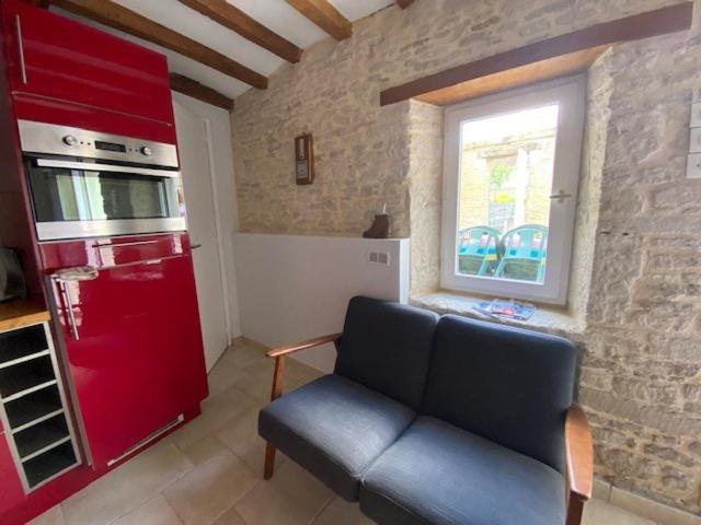 - un salon avec un canapé et un réfrigérateur rouge dans l'établissement Maison de Bourg, à Hermanville-sur-Mer