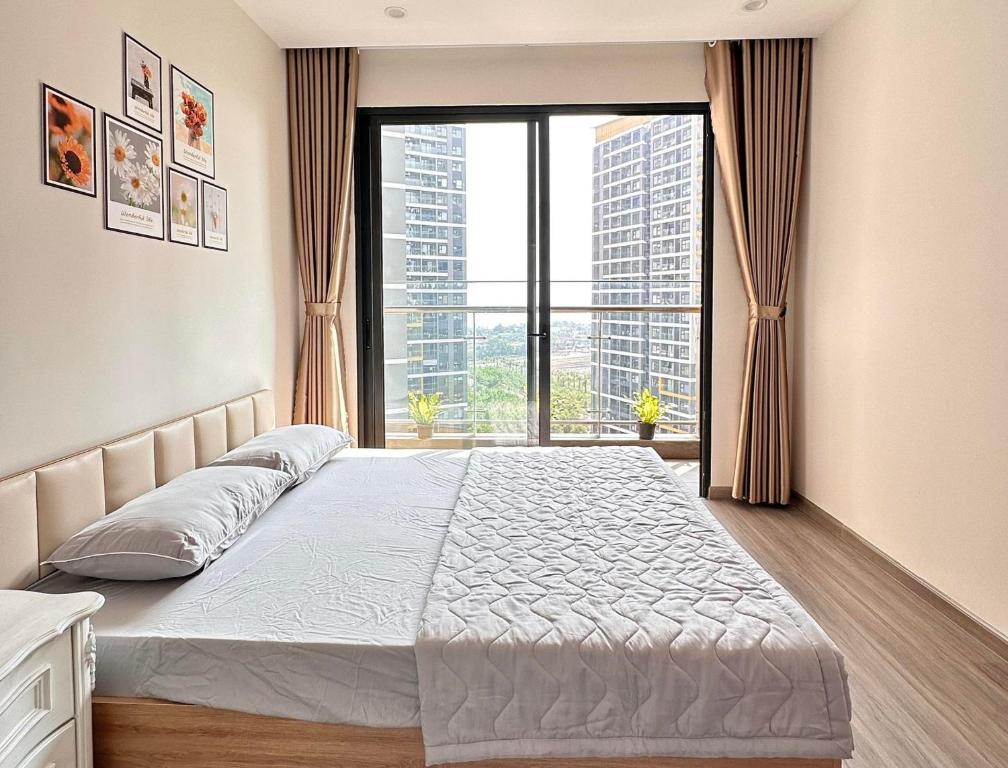 a bedroom with a bed and a large window at 2 phòng ngủ Solari nhìn công viên liền kề Vincom Mega Mall in Long Bình