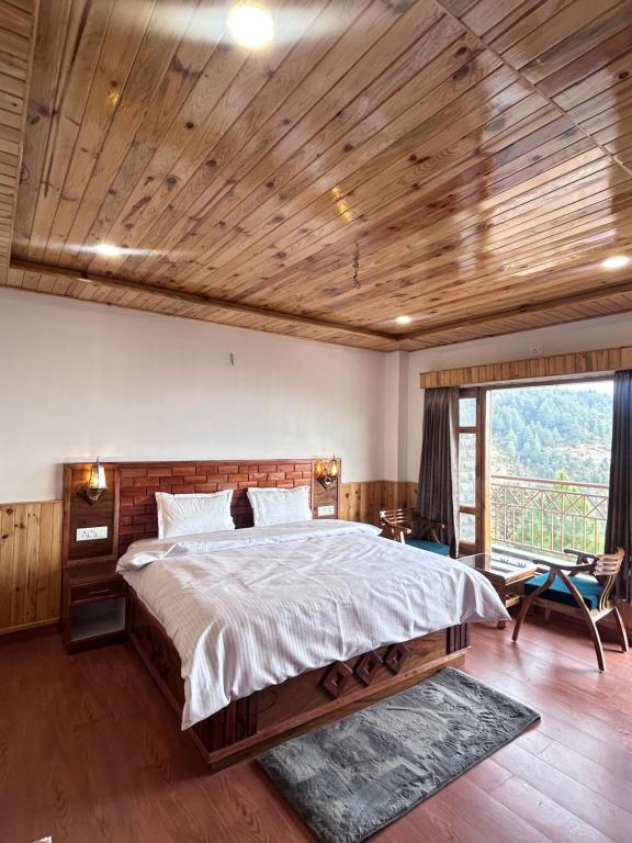 een slaapkamer met een groot bed met een houten plafond bij Shalom Hillcrest Inn in Shimla