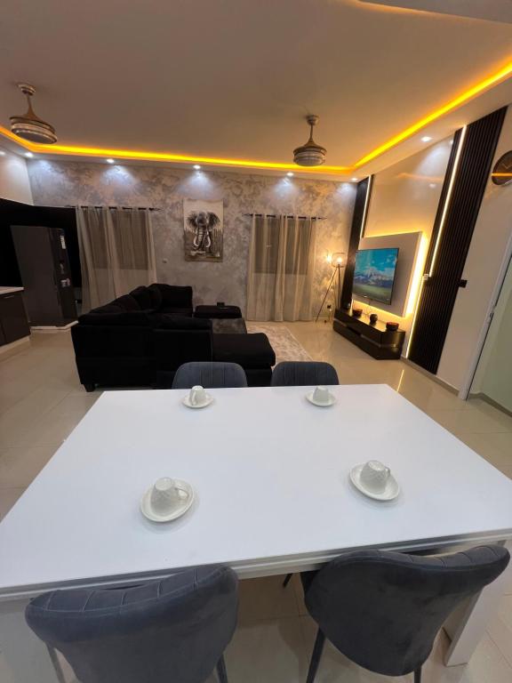 a white table and chairs in a living room at Le spacieux bis in Dakar