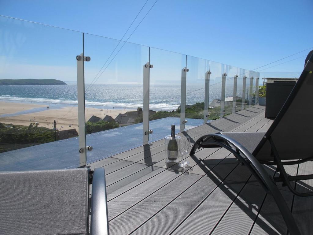 eine Flasche Wein auf einer Terrasse mit Blick auf den Strand in der Unterkunft Beautiful 2 bed apartment with stunning sea views in Woolacombe