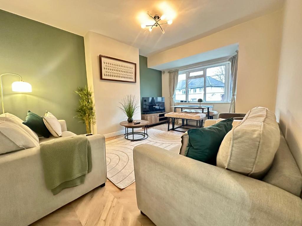 a living room with two couches and a television at Lovely spacious 3 double bed flat, LS17 in Leeds