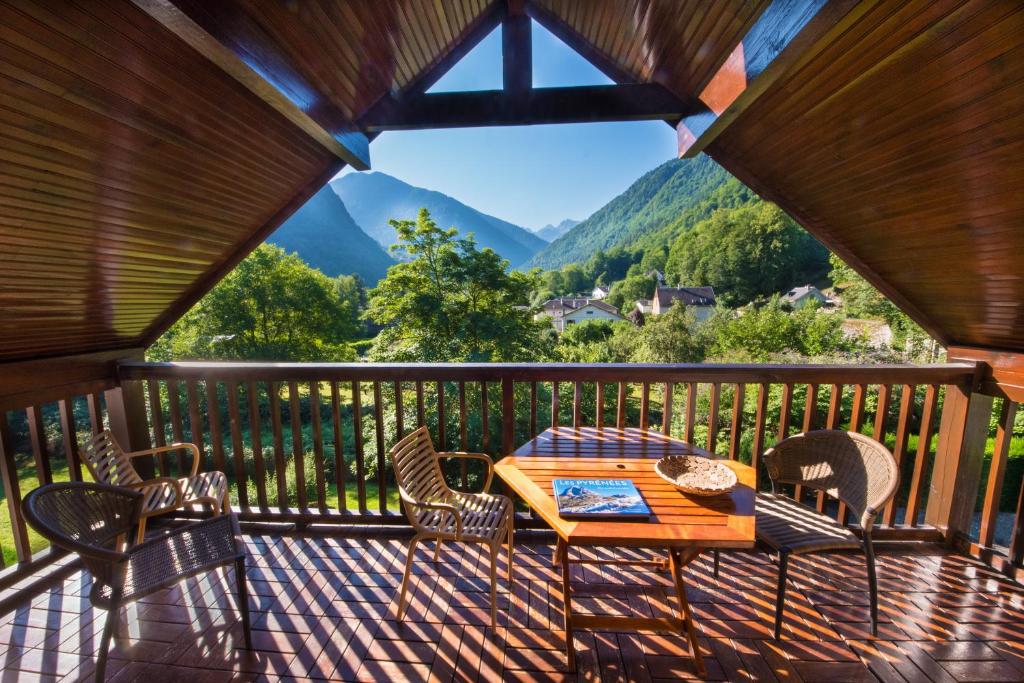 une table et des chaises sur un balcon avec vue dans l'établissement Agréable T2, 700m du pôle thermoludique de Luchon, à Luchon
