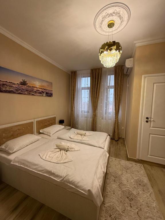 una camera da letto con un letto grande e un lampadario di Casa Bella a Medgidia