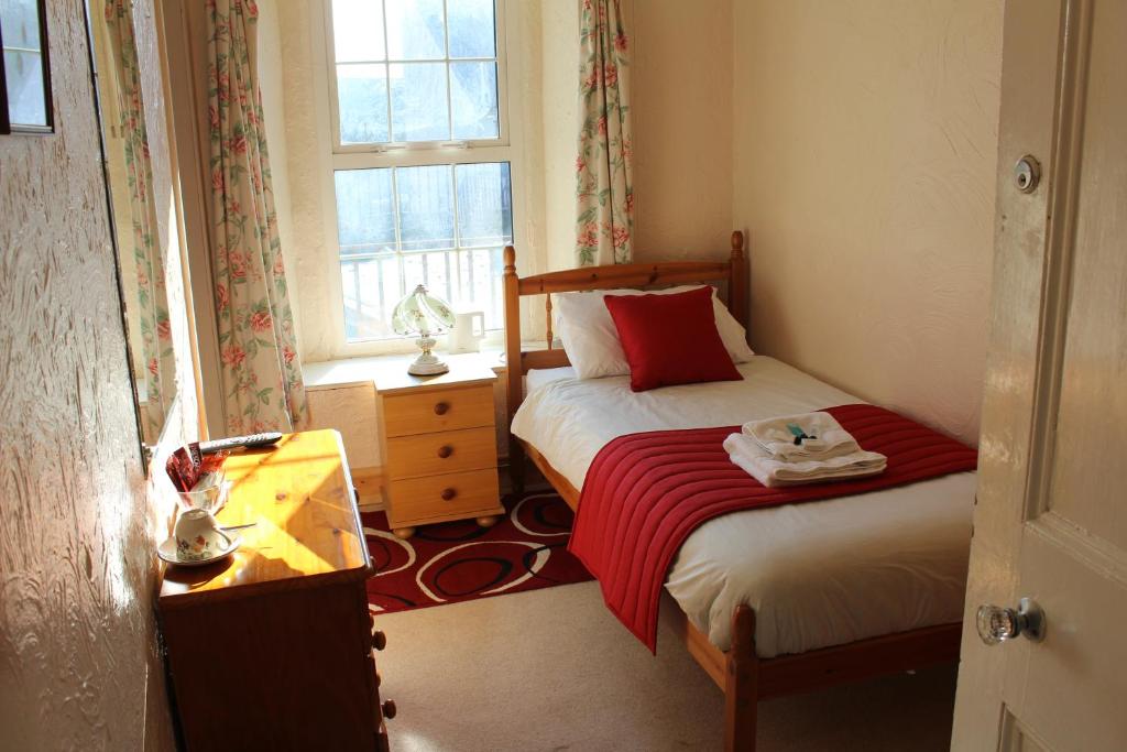 a bedroom with two beds and a desk and a window at Middlegate Hotel in Pembroke