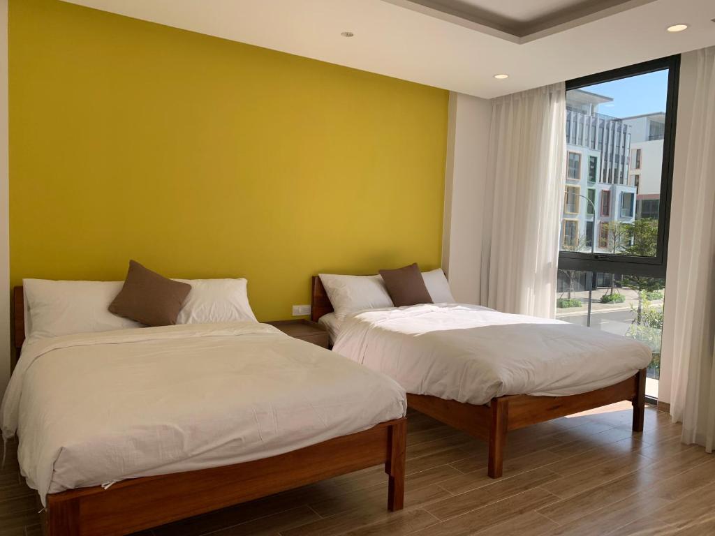富国Mey lnn Hotel Phu Quoc Island的黄色墙壁的客房内的两张床
