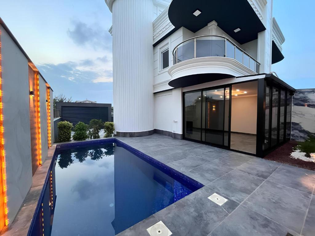 a house with a swimming pool in front of a house at Peaceful Holiday Villas-Barbecue in Belek