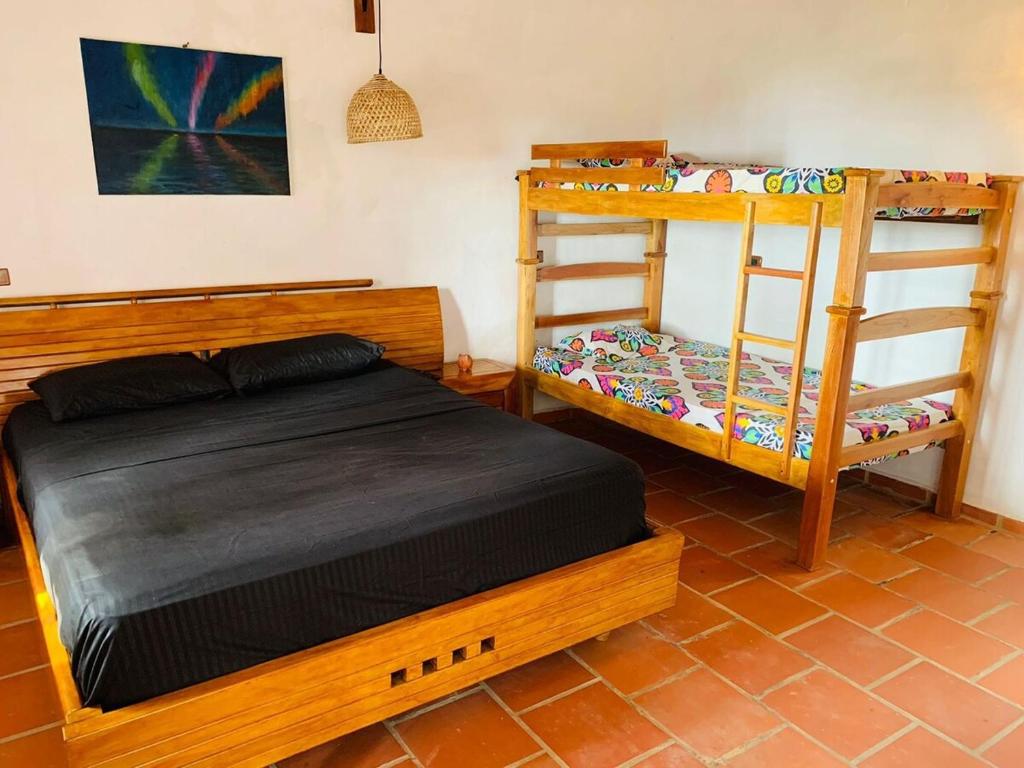 a bedroom with a bed and bunk beds with a ladder at Cabaña Umpalita para 4 cuatro personas in Los Santos