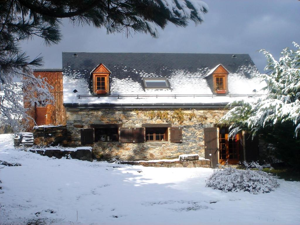 a house with snow on the roof of it at La grange des Quatre saisons in Gouaux-de-Luchon