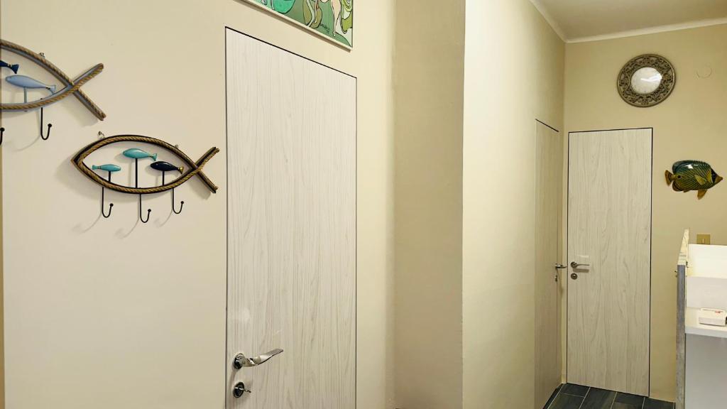 a bathroom with a white door and a clock on the wall at Maison Elsa in San Vito Chietino
