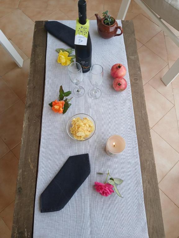 un tavolo con bicchieri da vino e fiori di Borgo Vignale a Santuario di Gibilmanna