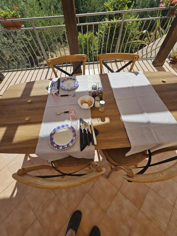un tavolo in legno con un piatto di cibo su una terrazza di Borgo Vignale a Santuario di Gibilmanna