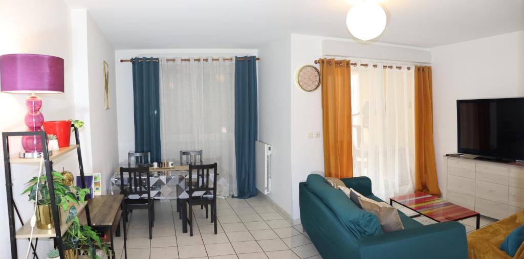 un salon avec un canapé bleu et une table dans l'établissement Le Madeleine - Parking gratuit- Balcon - Fibre, à Orléans