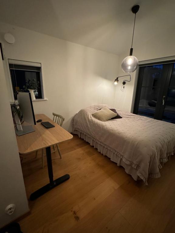 a bedroom with a bed and a desk with a laptop at Boende på Marholmen in Norrtälje