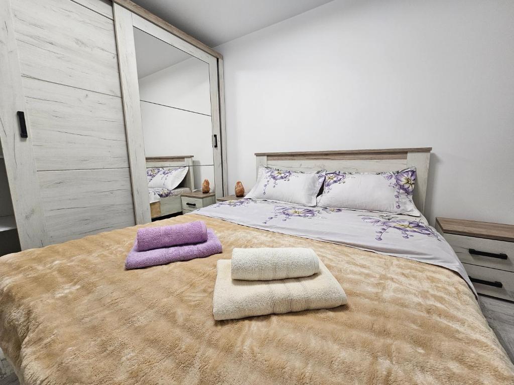 una camera da letto con un letto grande con due asciugamani sopra di Apartment central Lupeni-Straja a Lupeni