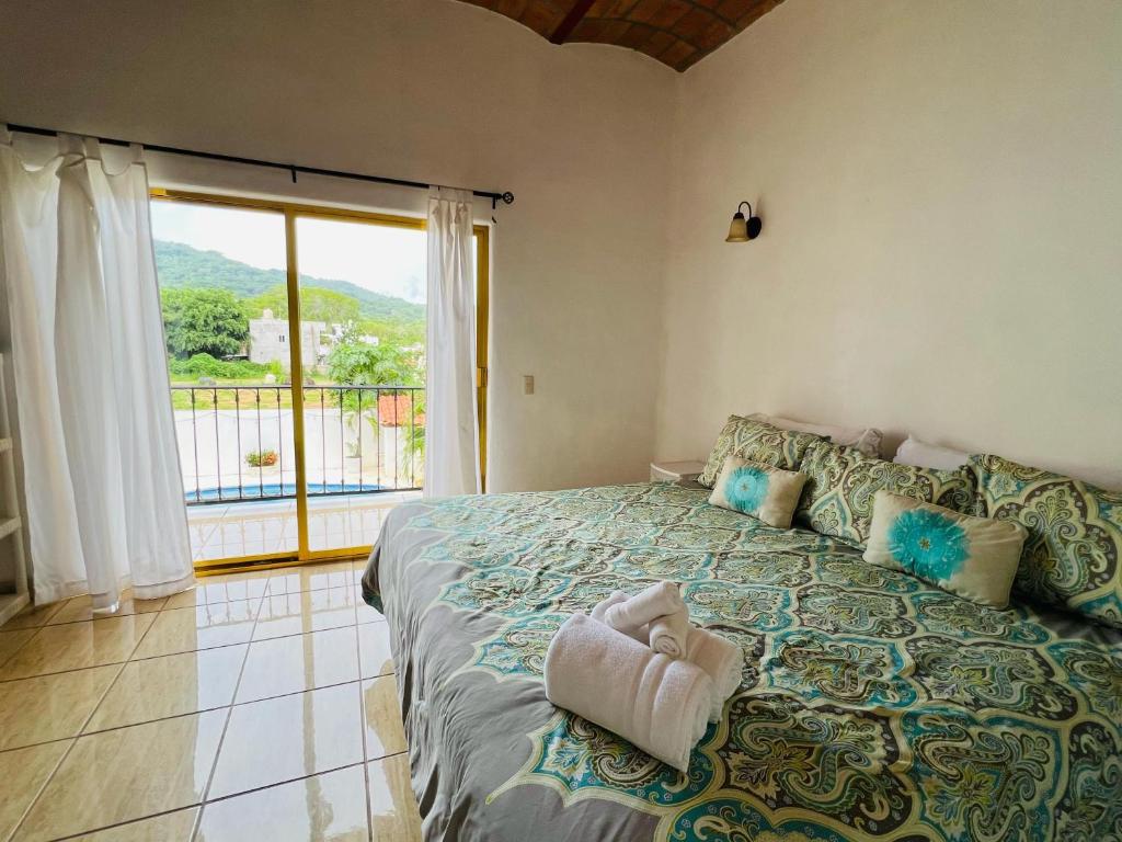 a bedroom with a large bed with a large window at Paraiso Escondido in Lo de Marcos