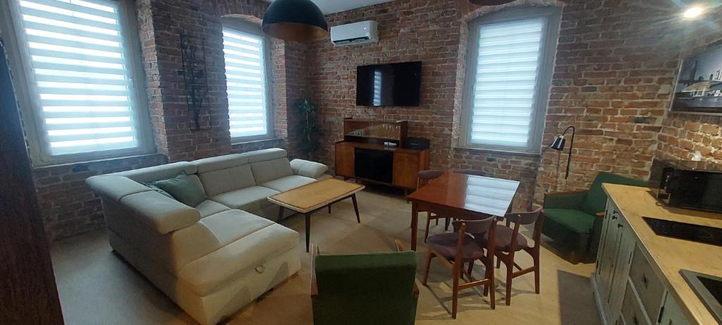 a living room with a couch and a table at Apartament Przygórze 212 in Przygórze