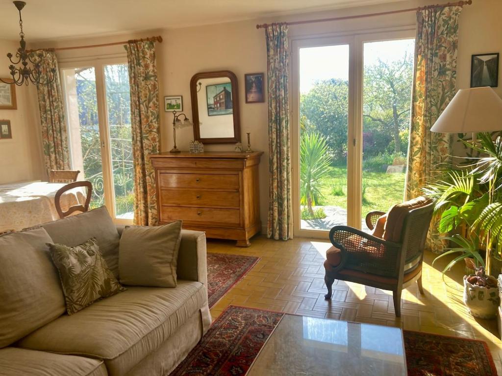 a living room with a couch and a mirror at Maison aux camélias in Locquénolé