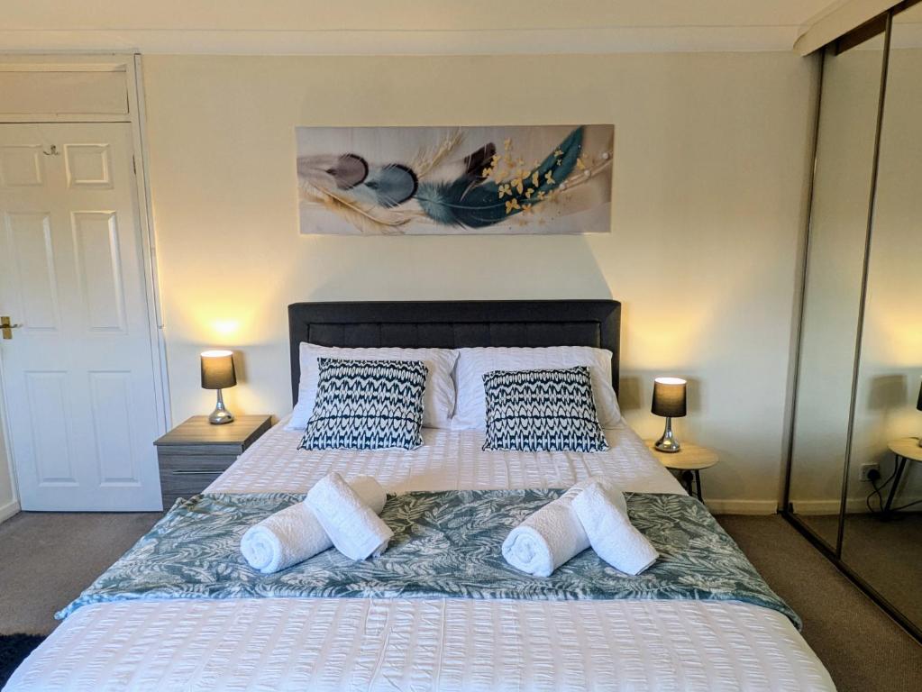 a bedroom with a large bed with blue and white pillows at Theatre Severn Town House, Parking & Quarry Views in Shrewsbury