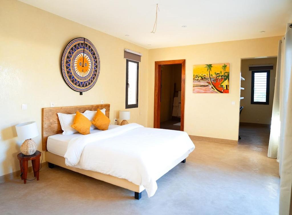 a bedroom with a large white bed with orange pillows at Maison Inaya in Ngaring