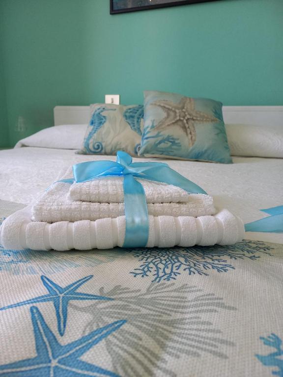 a bed with a pile of towels on it at B&B La casa di Dorothy in Telti