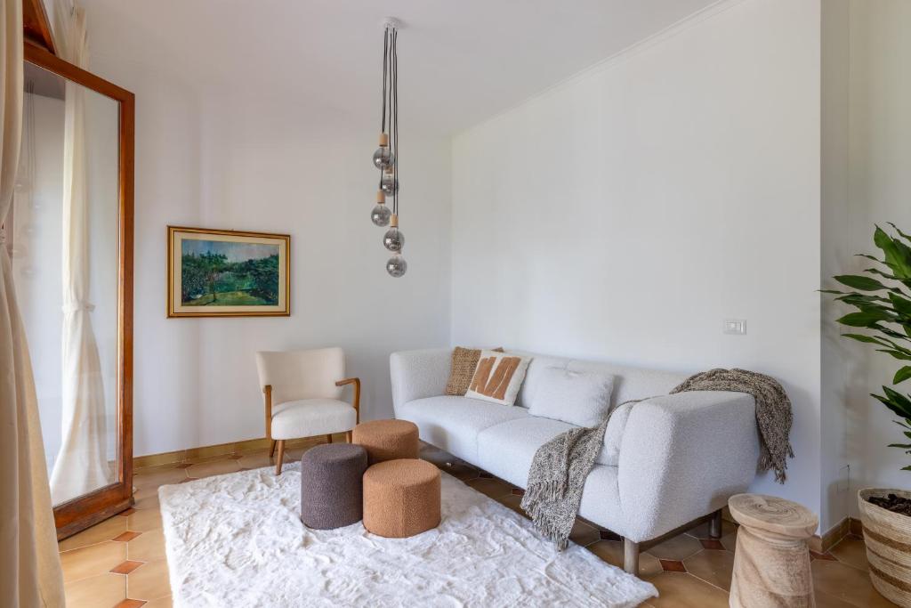 una sala de estar con un sofá y una silla en Spaziosa Villa con piscina, BBQ e campi da tennis, en Casal Palocco