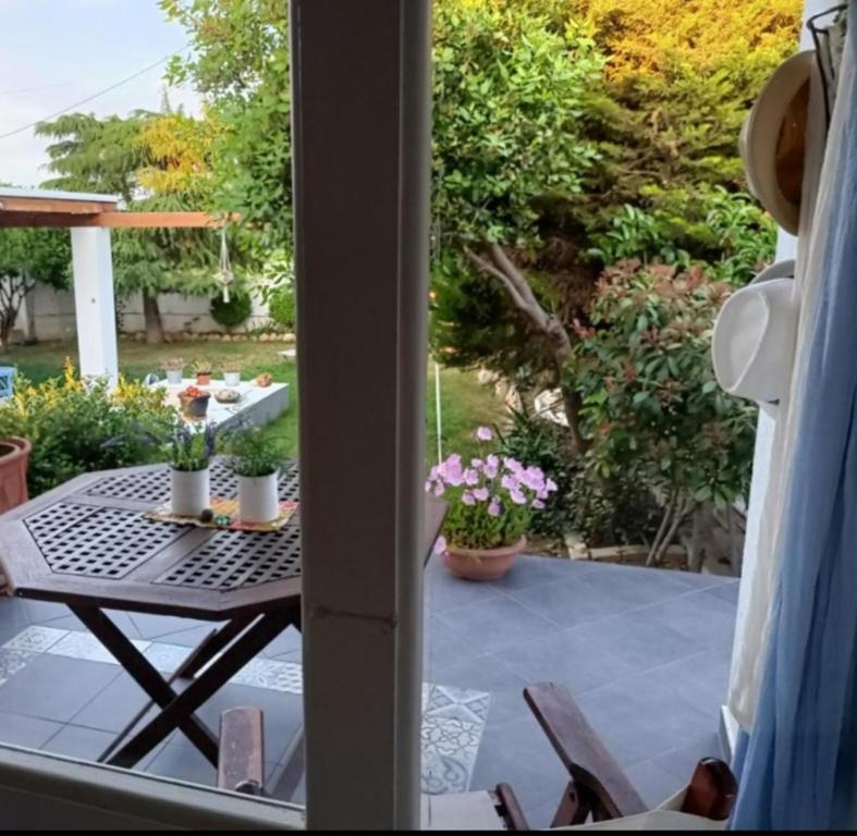 an open door to a patio with a table and flowers at Casa Martina 2 (Spata) 10min El.Venizelos airport. in Spáta