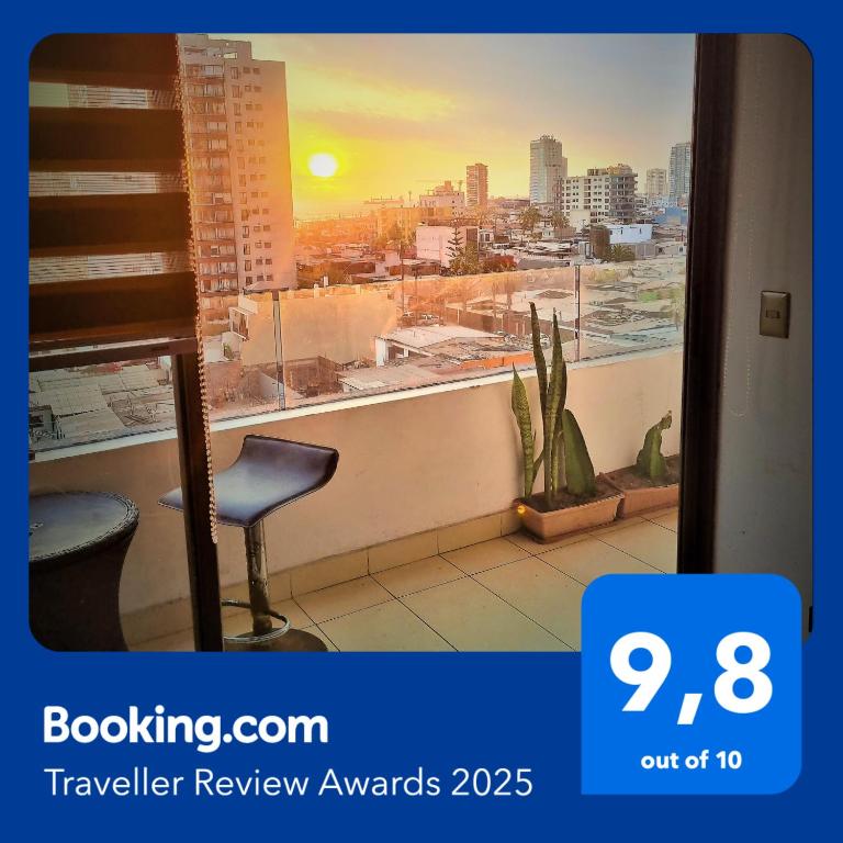 a view of a city from a window with a chair at Cavancha Exclusivo in Iquique