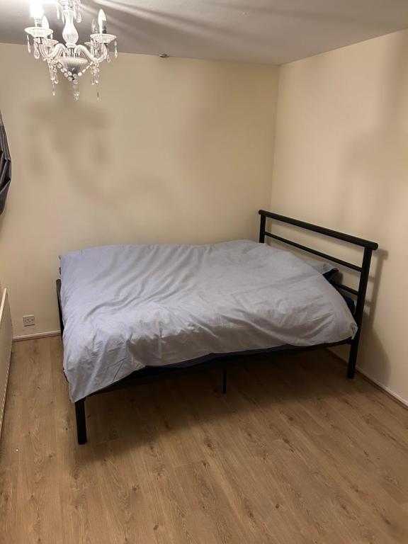 una cama en una habitación con una lámpara de araña en Lovely Milton Keynes Double Room, en Milton Keynes