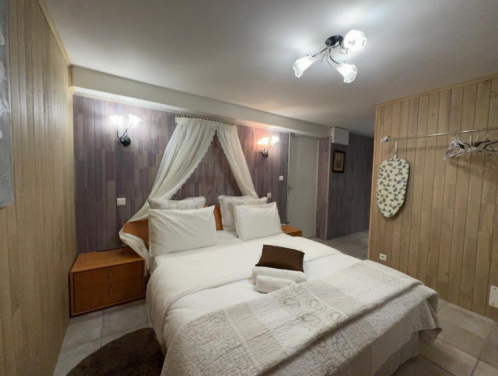 une chambre avec un grand lit blanc avec un ventilateur de plafond dans l'établissement Chambres d'hôtes salles de bain intégrée et entrée privée , parking gratuit, à Sarlat-la-Canéda