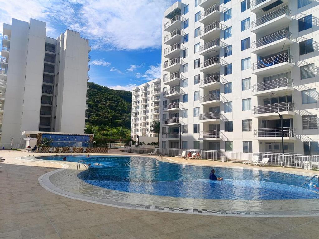 una persona en una piscina junto a un edificio en Fresco Apartamento En Girardot Elegante, en Girardot