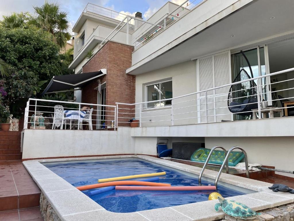 una casa con piscina delante de una casa en Entire villa with pool, ocean & mountain views, en Sitges