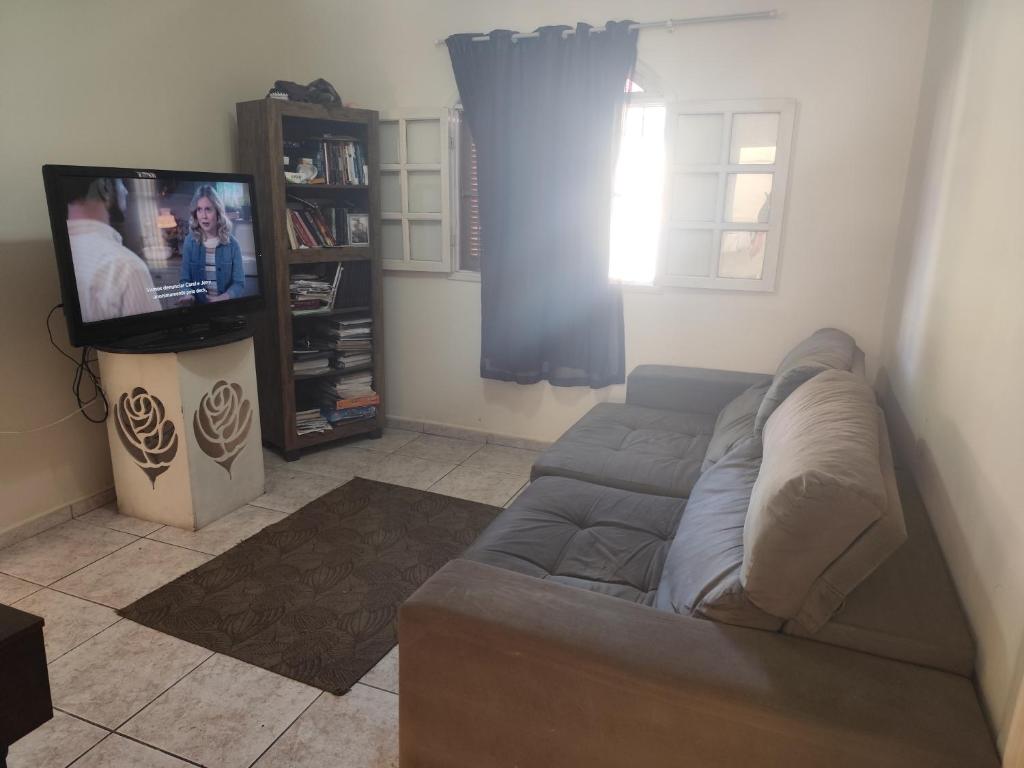 ein Wohnzimmer mit Sofa und Flachbildfernseher in der Unterkunft Lar da prainha in Arraial do Cabo