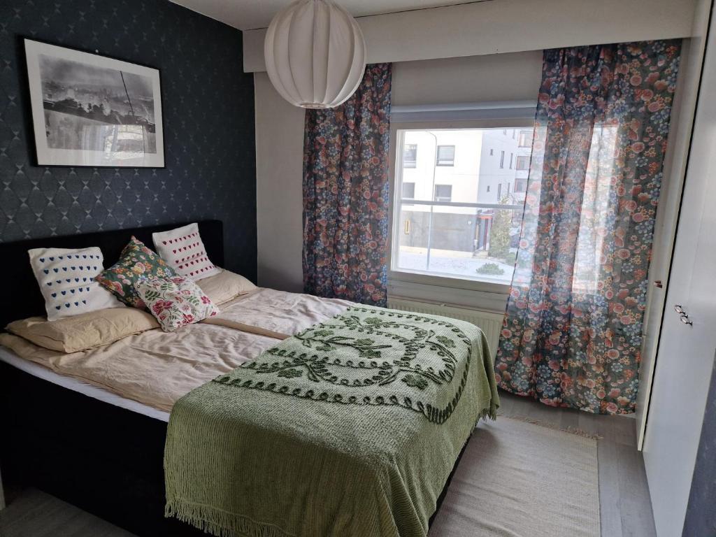 a bedroom with a large bed with a window at Apia Super Stay, Sauna, 5pers in Valkeakoski