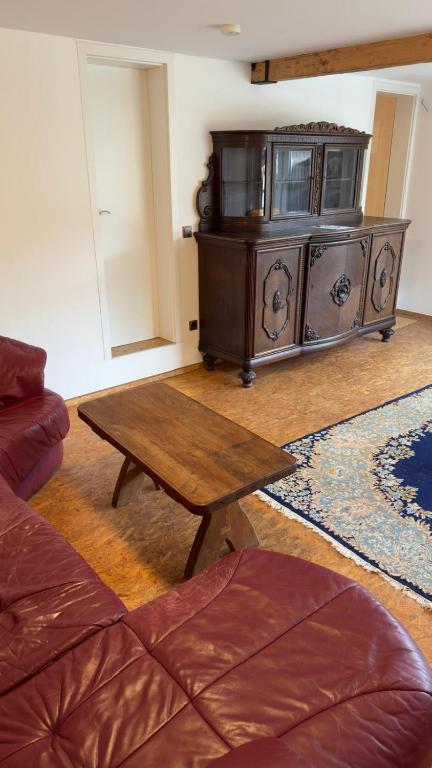 a living room with a wooden table and a couch at Ferienwohnung Monteurzimmer Zülpich Bauernhof in Zülpich