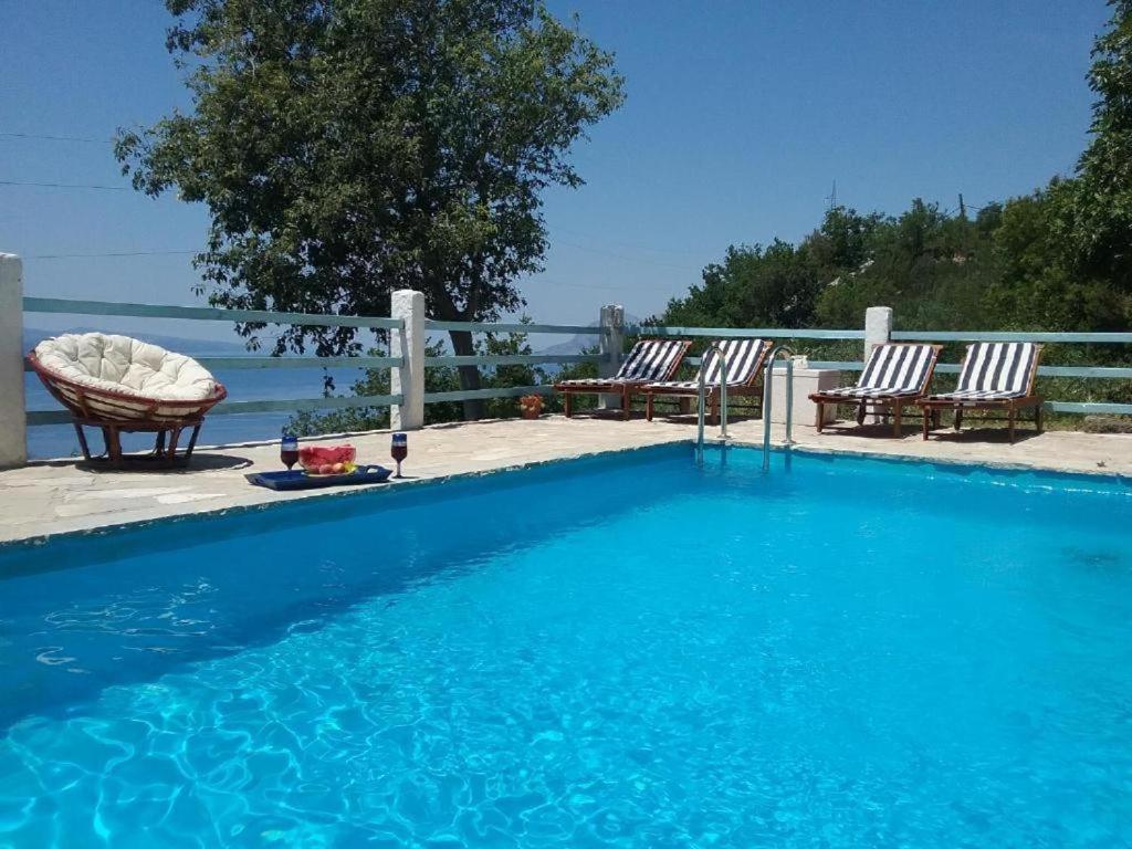 a swimming pool with two chairs and a table at Stone house in Brela