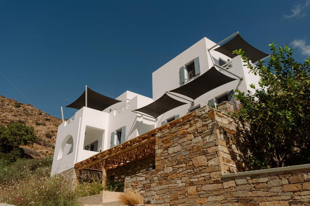a white building sitting on top of a stone wall at Gianemma Luxury Apartments in Mylopotas