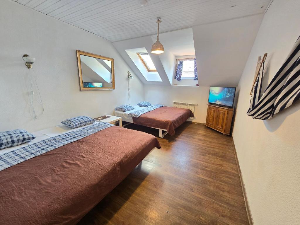 a room with two beds and a television in it at M5 Meridian Apartment in Klaipėda