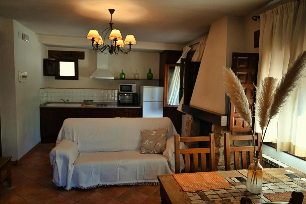 a living room with a couch and a kitchen at Casa Rural Nelia in Villalba de la Sierra