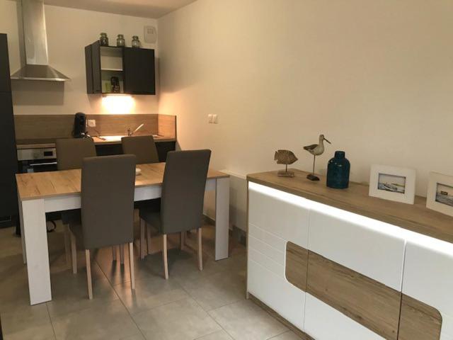 une cuisine avec une table et des chaises dans une cuisine dans l'établissement ApptT2 neuf Port de Saint Valéry sur Somme, à Pinchefalise