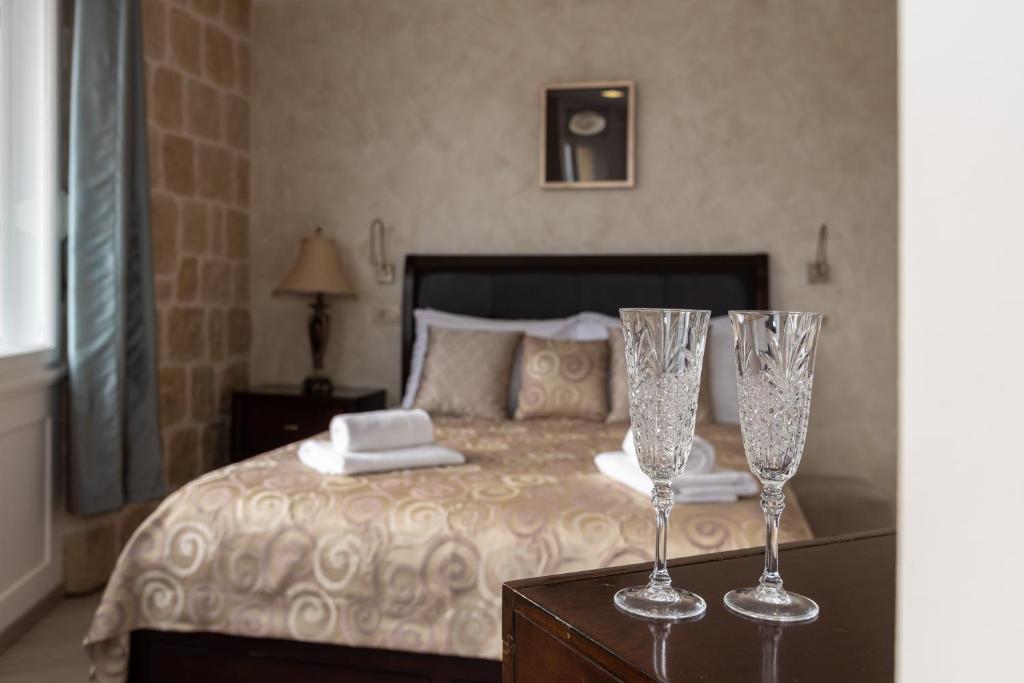 two champagne glasses sitting on a table in a bedroom at Queen Teuta Luxury Rooms Split in Split