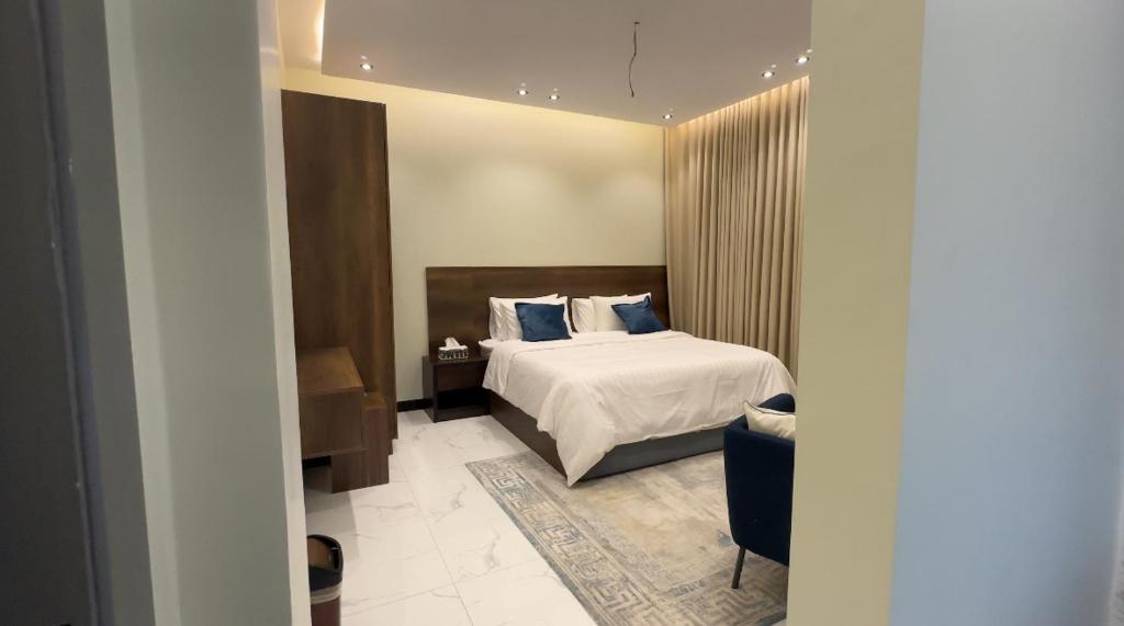 a bedroom with a bed with blue pillows at شقق العامر in Jeddah