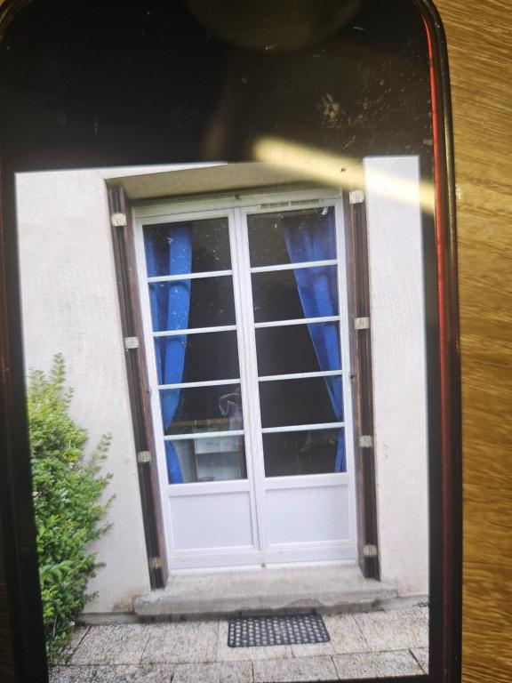 une porte menant à une maison avec une fenêtre dans l'établissement Kiki, à La Bourboule