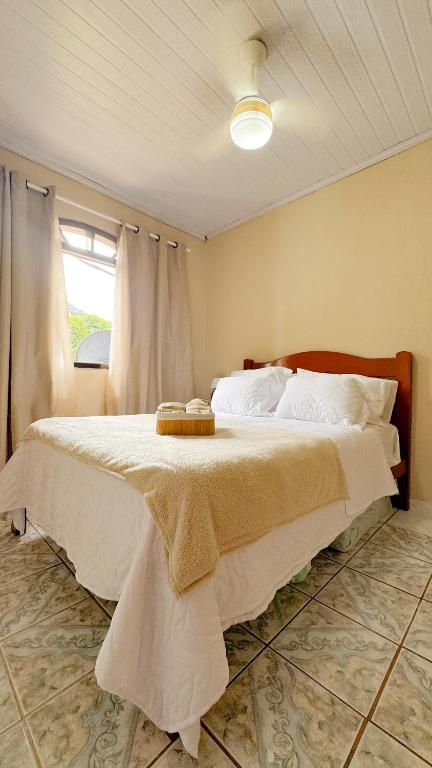 - une chambre avec un grand lit et une table dans l'établissement Casa na Vila do Abraão - Ilha Grande, à Angra dos Reis