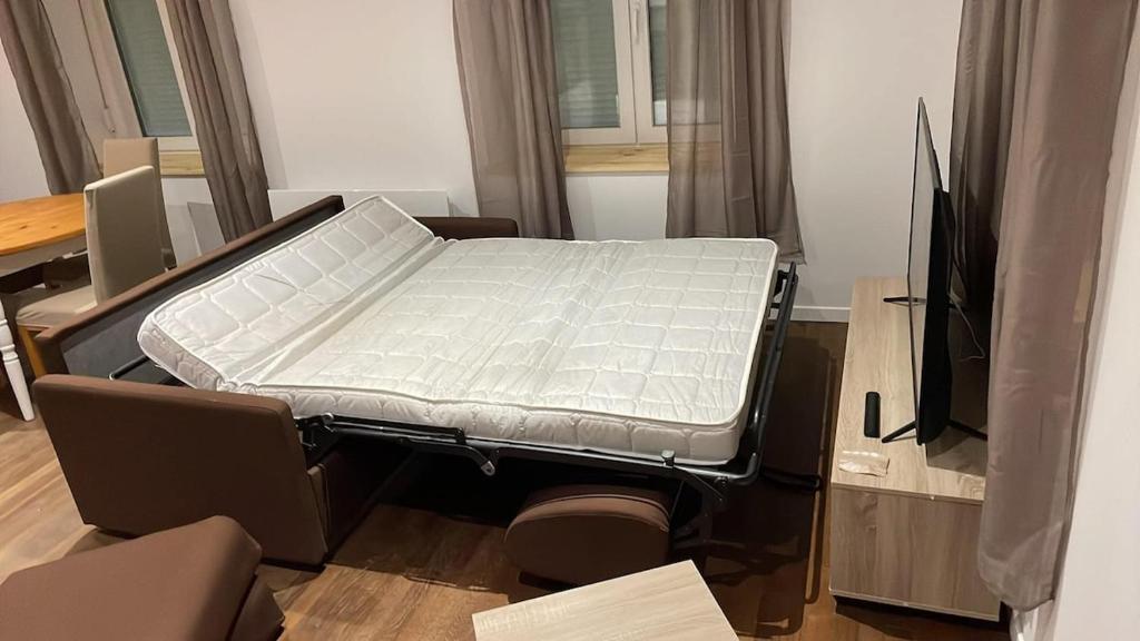 BlagnyAppt RDC meublé 2 ou 4 pers的一间带电视的房间里的一张病床