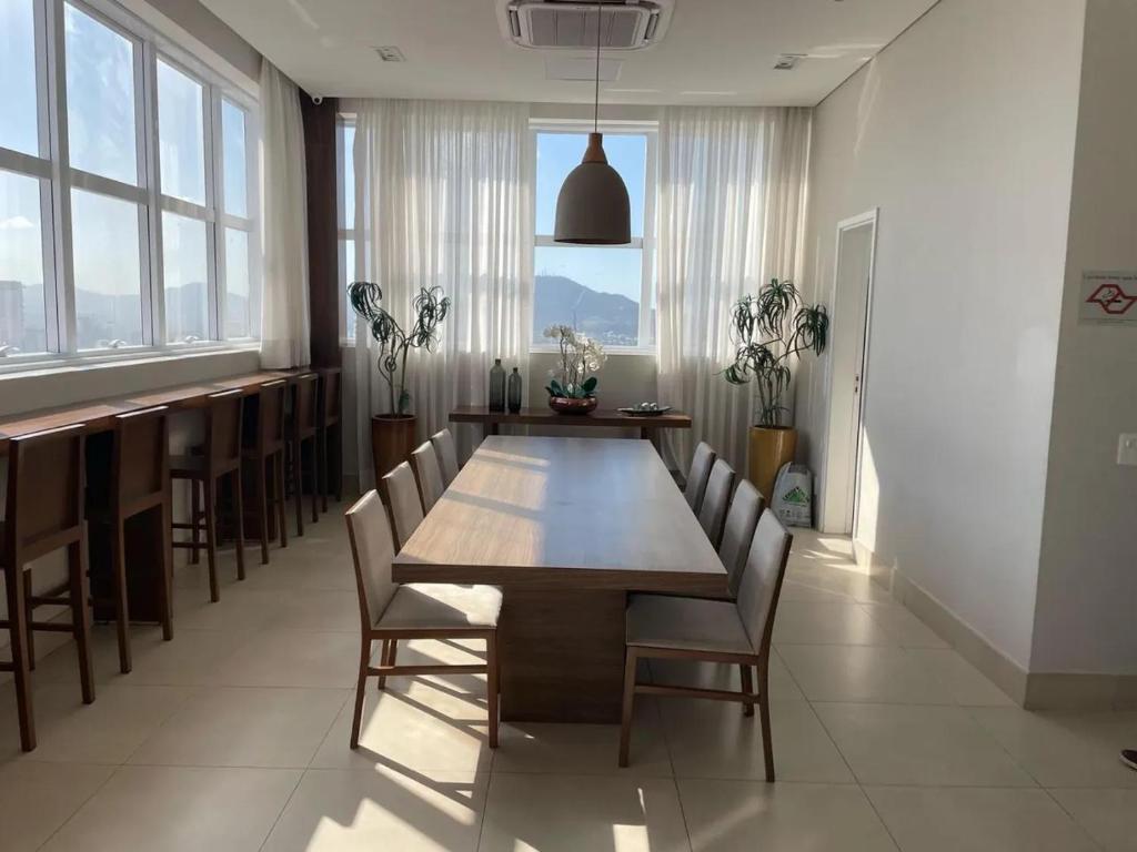 a dining room with a large wooden table and chairs at Espaço Das Flores in Salvador
