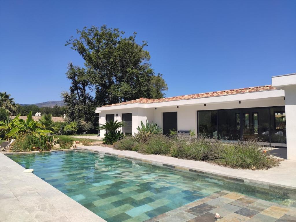 une piscine devant une maison dans l'établissement Villa avec piscine au milieu des bois, à Roquefort-les-Pins