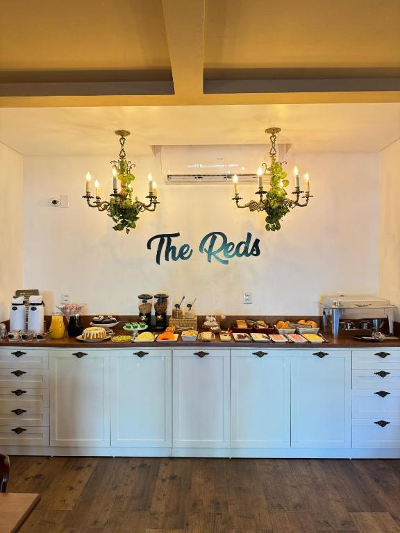 a kitchen with white cabinets and a sign that reads the nets at The Reds Pousada in Penha